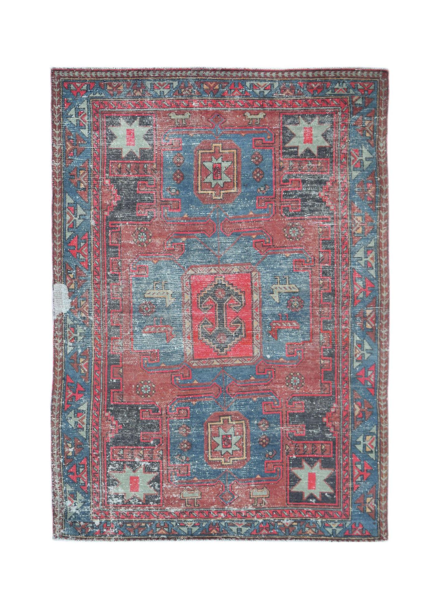 A vintage handwoven Persian rug featuring a geometric pattern in shades of red and blue.