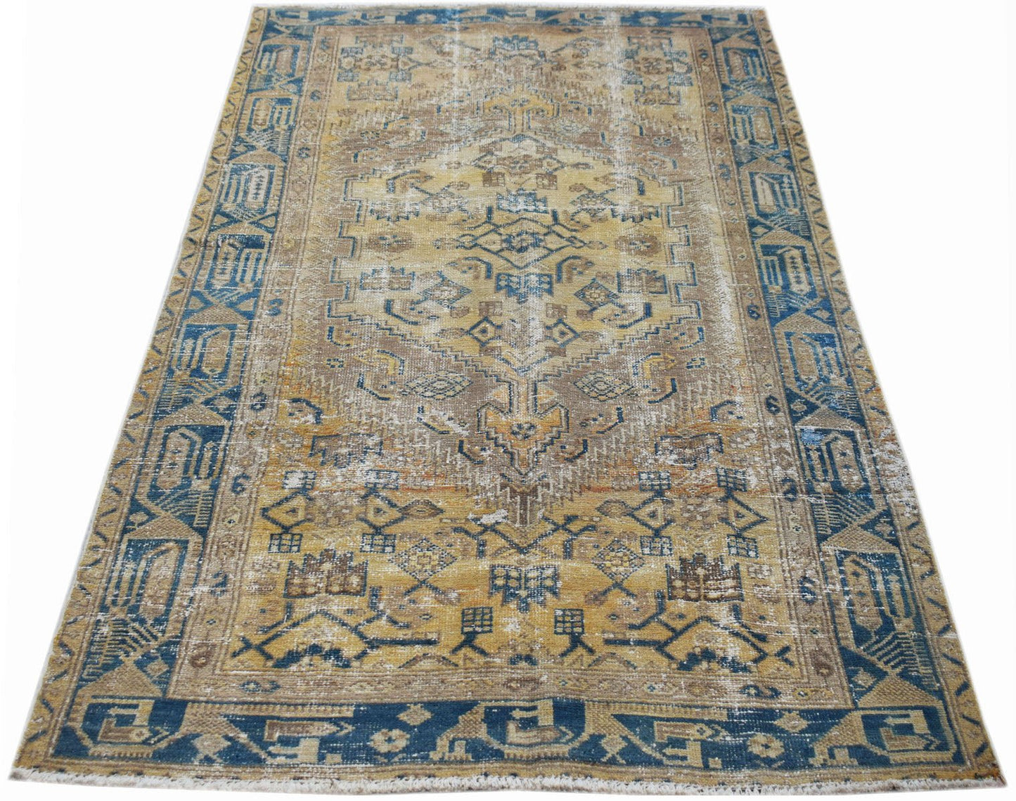 A rectangular vintage Persian rug featuring a distressed geometric pattern in blue and gold tones.