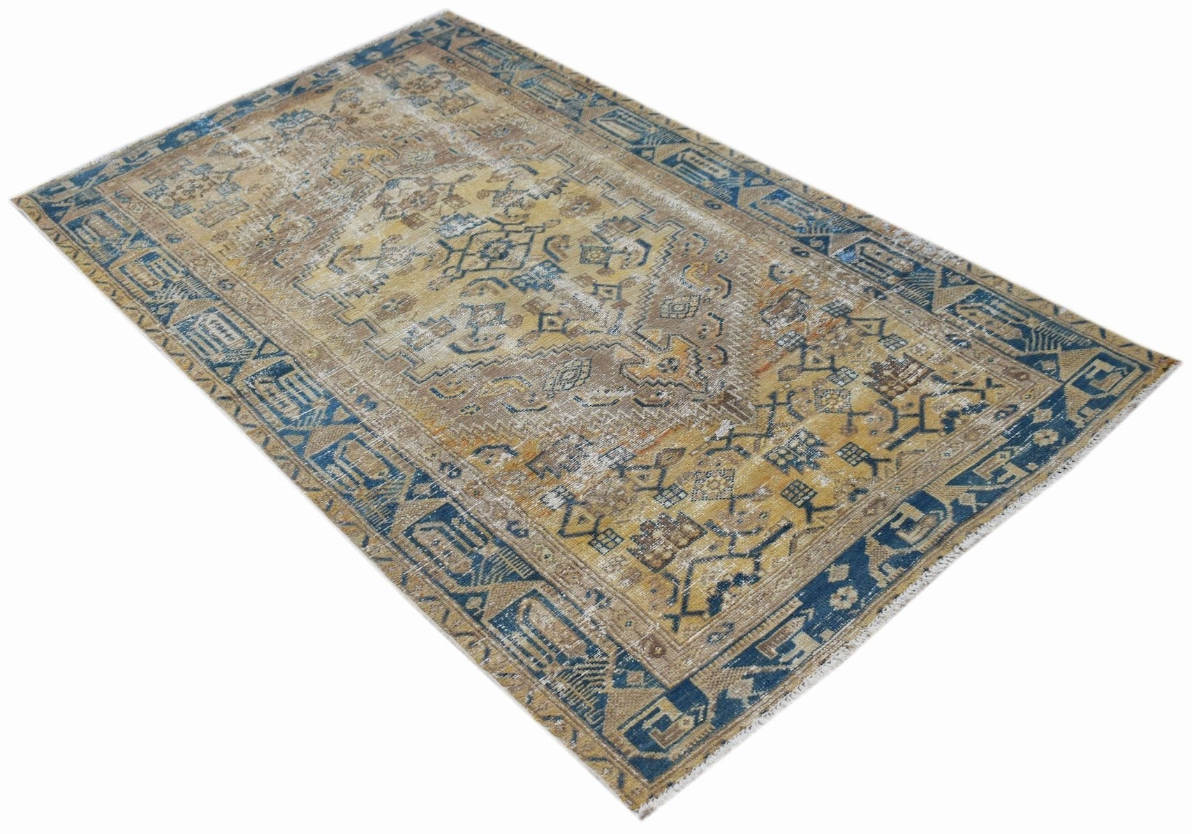 A vintage handwoven Persian rug featuring a distressed pattern in shades of blue and gold.