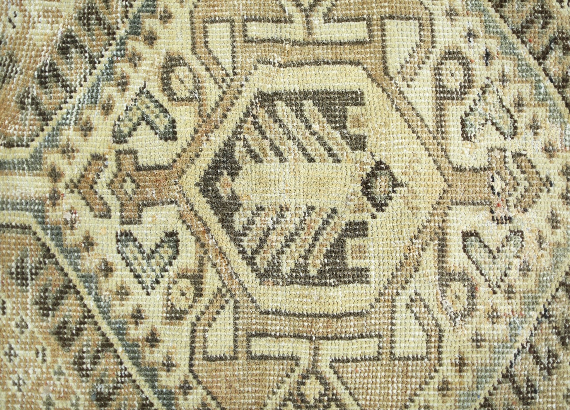 A close-up of a vintage Persian Qashqai rug featuring intricate geometric patterns in neutral tones.