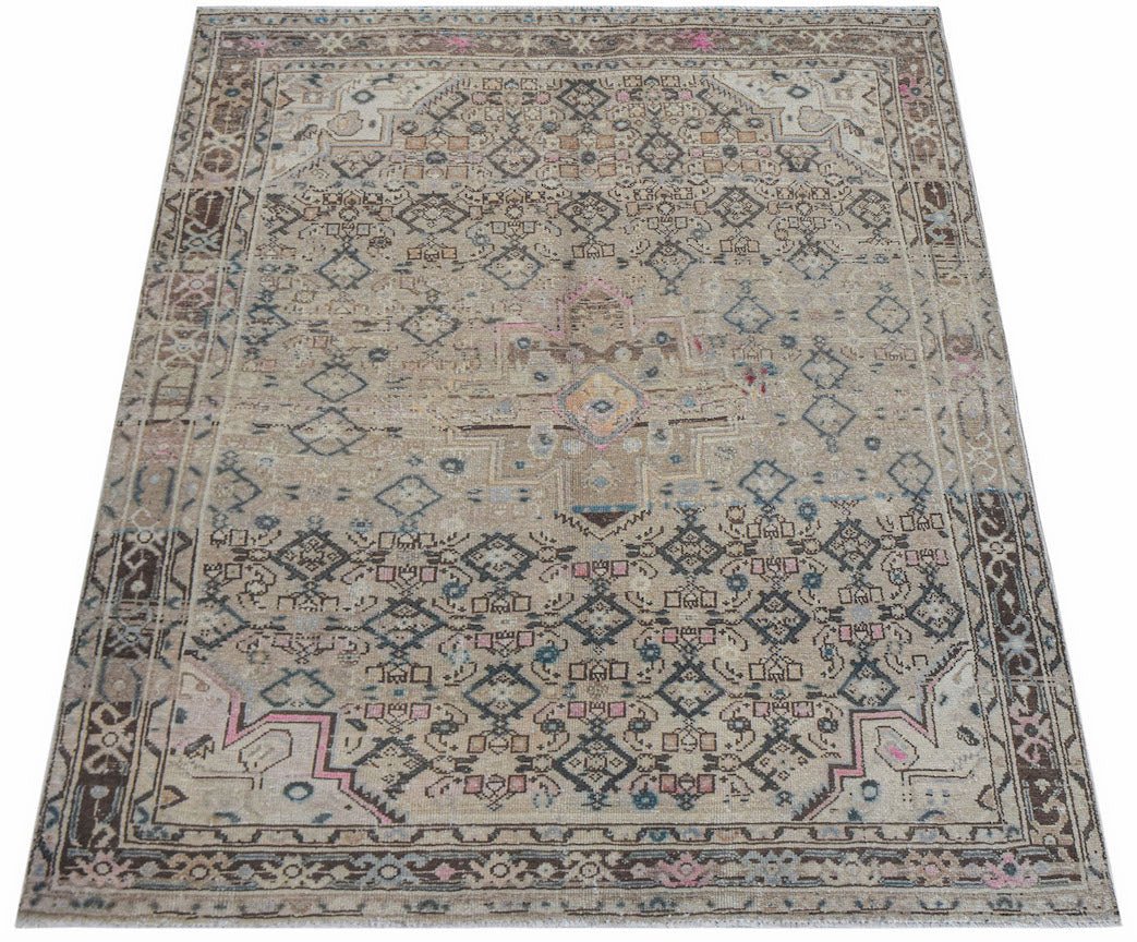 A handwoven vintage Persian rug featuring a faded geometric pattern in neutral and muted tones.