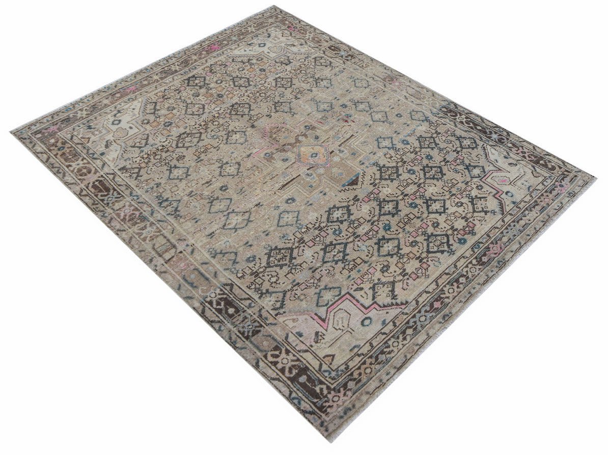 A handwoven vintage Persian rug featuring a faded geometric pattern in neutral and muted tones.