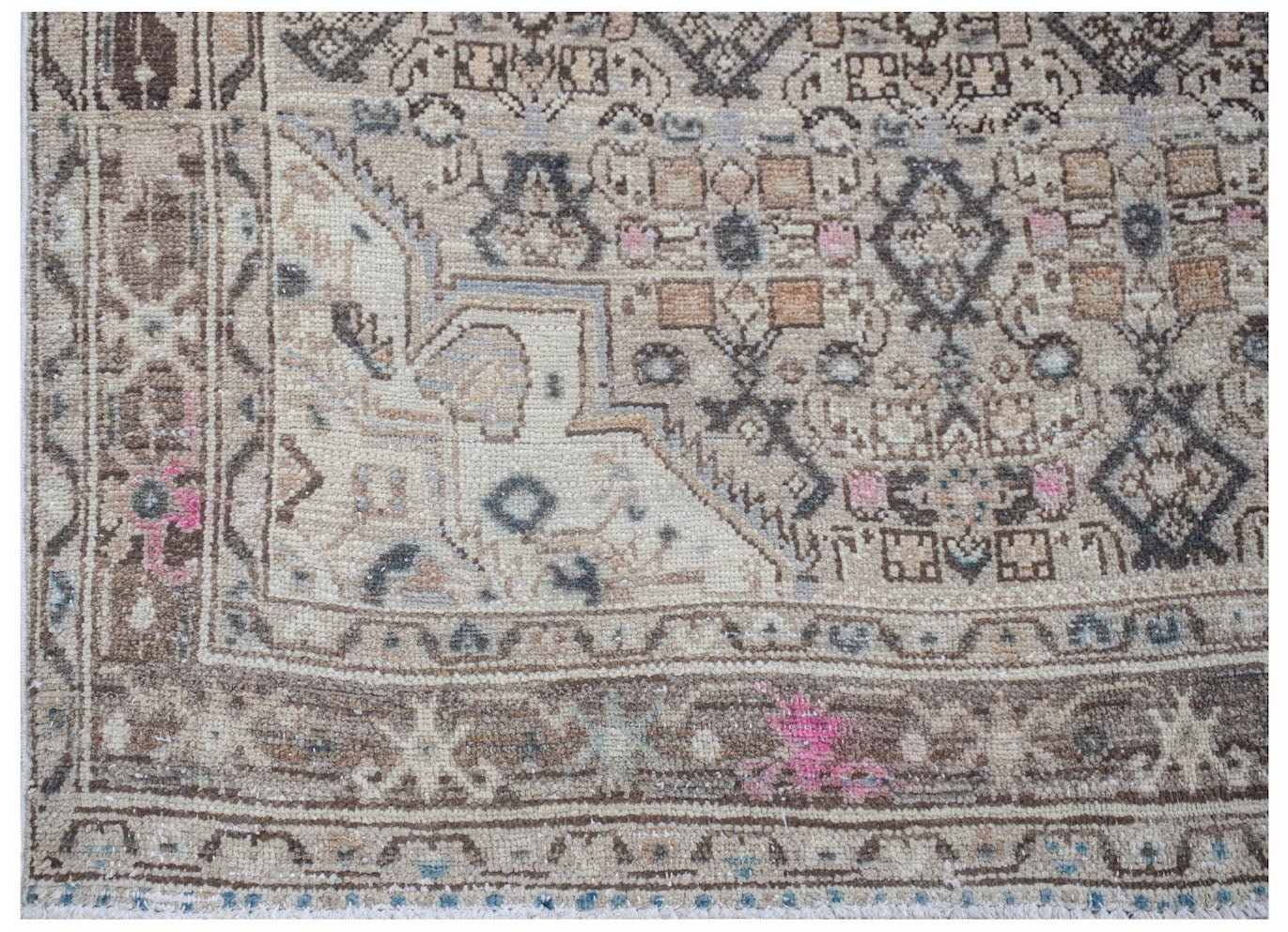 Vintage Persian rug with intricate geometric patterns in neutral tones.