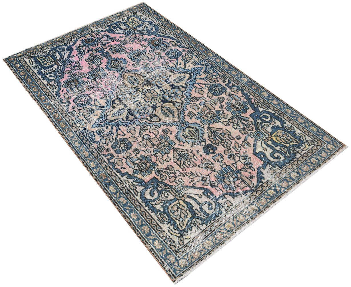 Vintage Persian rug with pink and blue floral patterns.