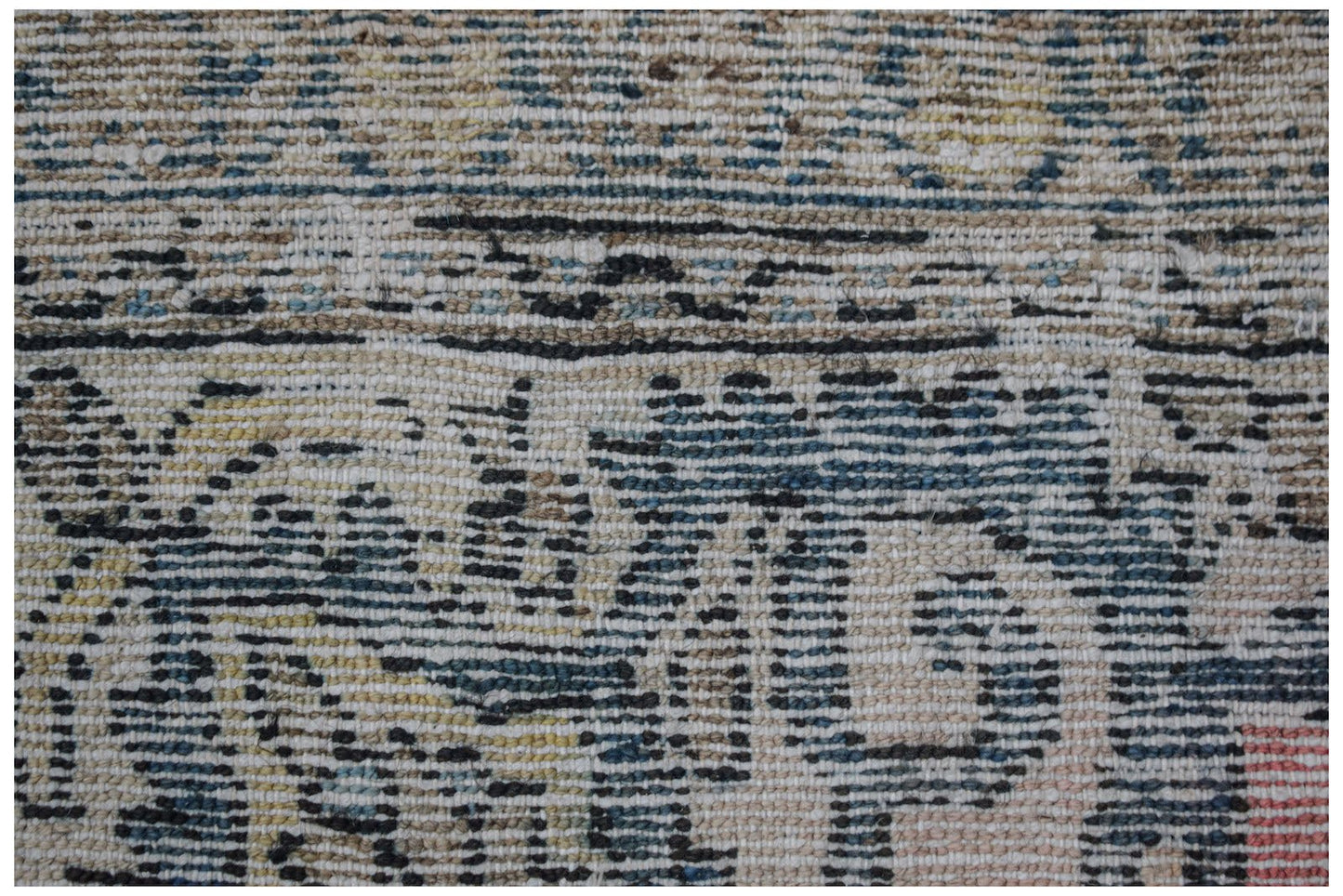 A close-up view of a handwoven vintage Persian rug featuring a distressed, multi-colored pattern.