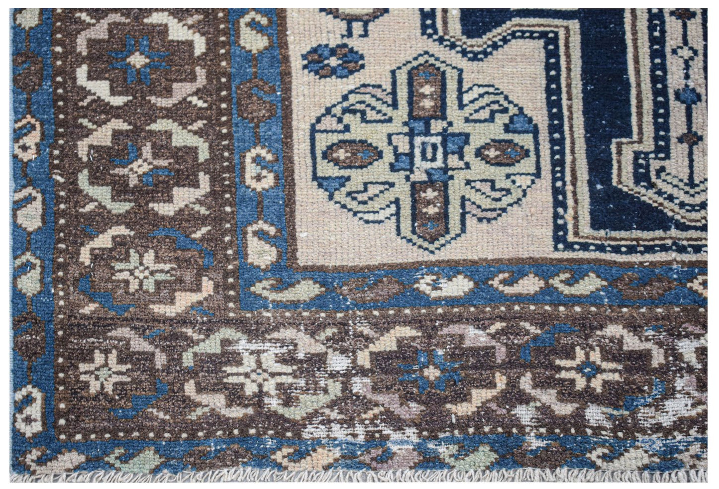 Vintage Persian rug with intricate brown, blue, and cream geometric patterns.