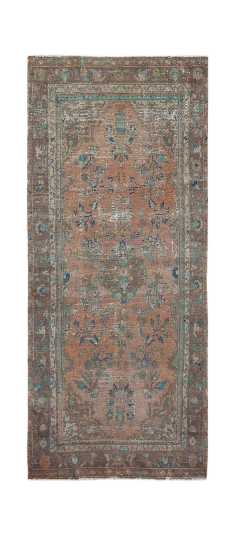 A vintage Persian Sarouk rug featuring a faded floral pattern in shades of orange, blue, and brown.