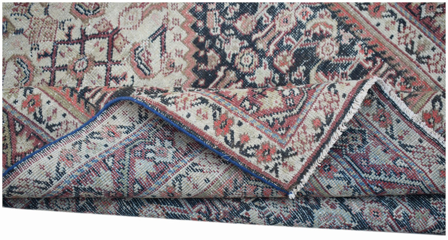 A handwoven vintage Persian rug featuring intricate floral patterns in red, blue, and cream.
