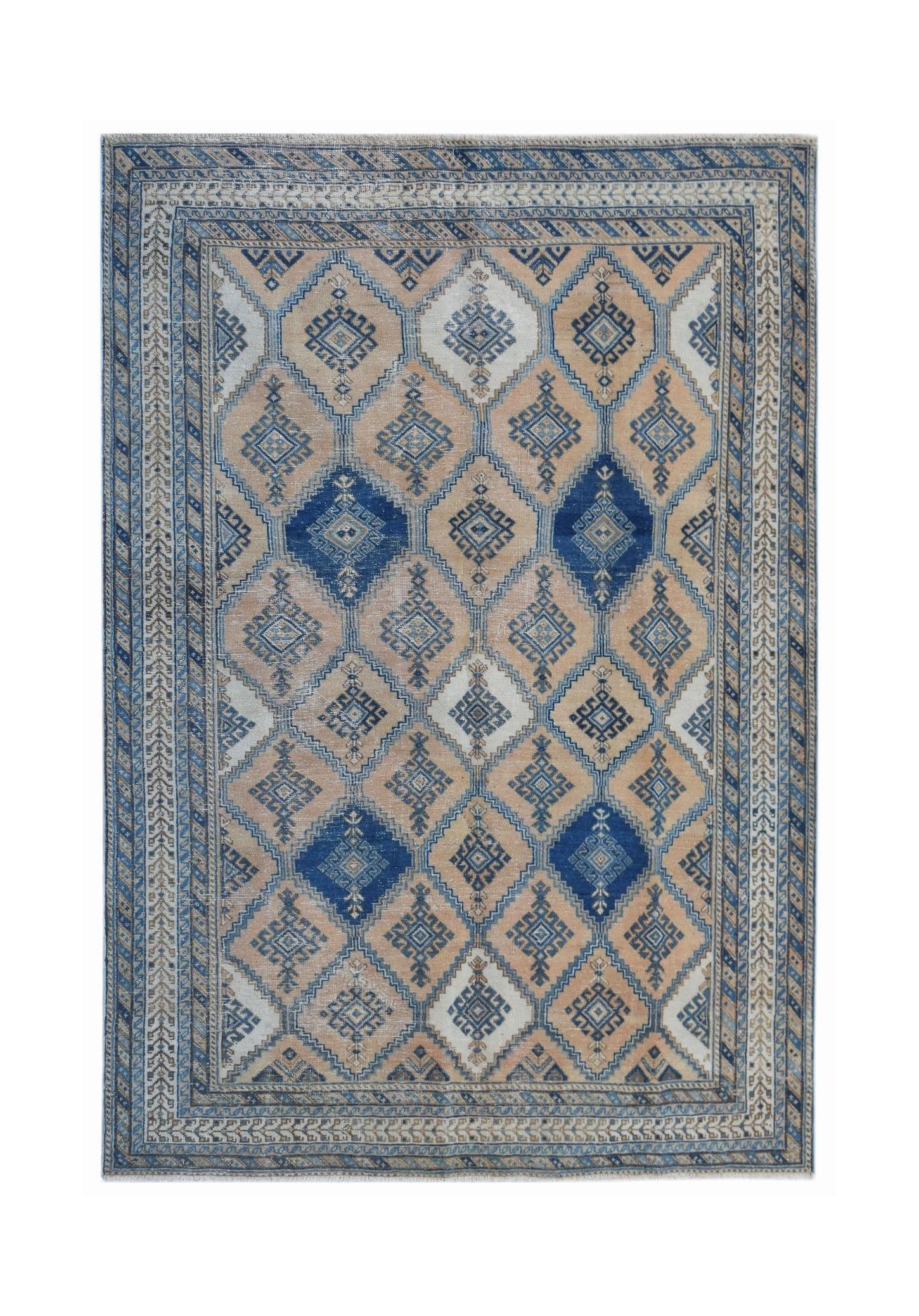 A vintage Persian rug featuring a geometric diamond pattern in shades of blue, beige, and cream.