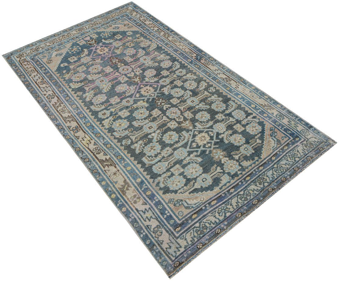 A handwoven vintage Persian Malayer rug featuring a traditional blue and beige floral pattern.
