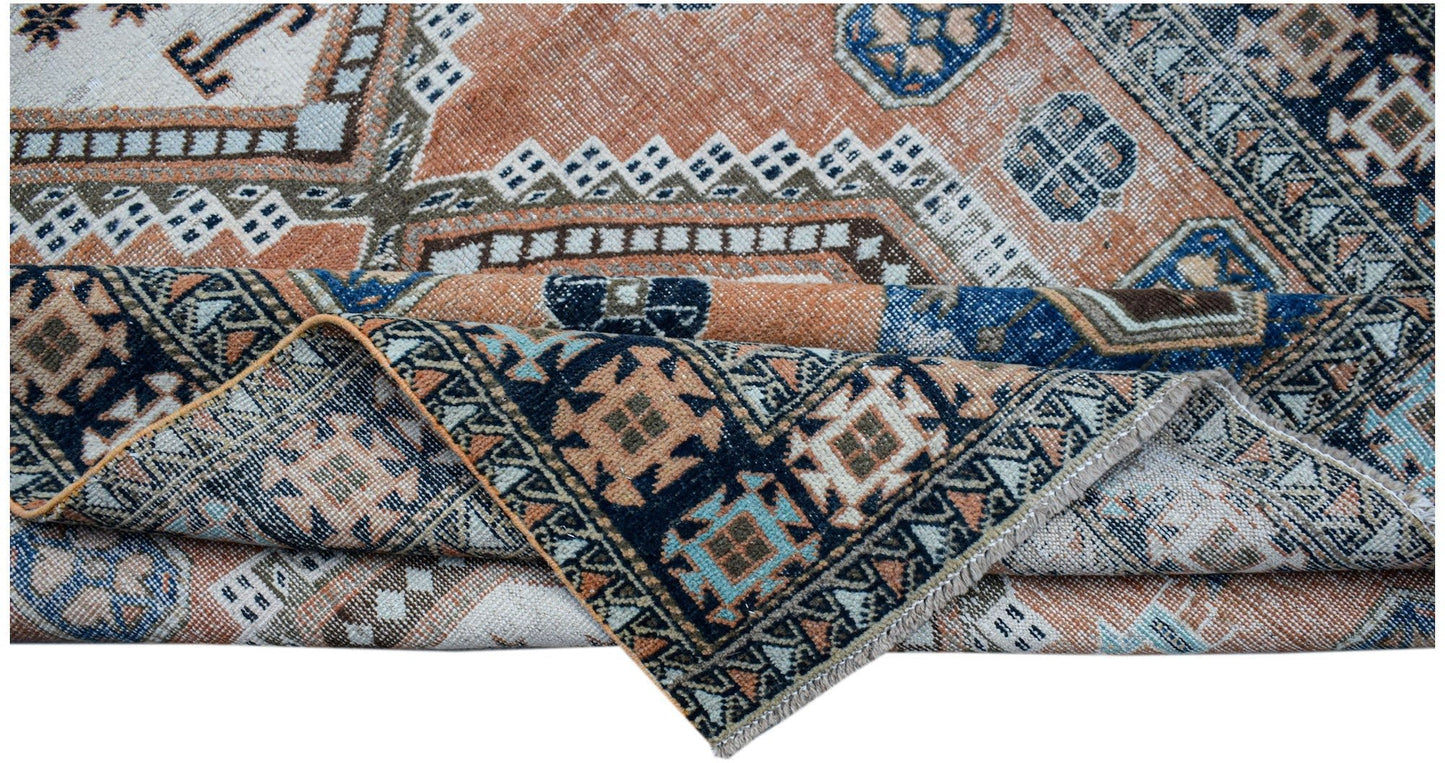 A handwoven vintage Persian rug featuring geometric patterns in shades of orange, blue, and cream.