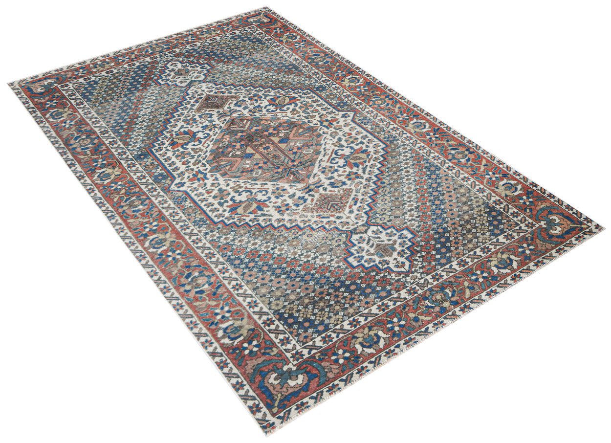 Vintage Persian rug with a central medallion and intricate geometric patterns.