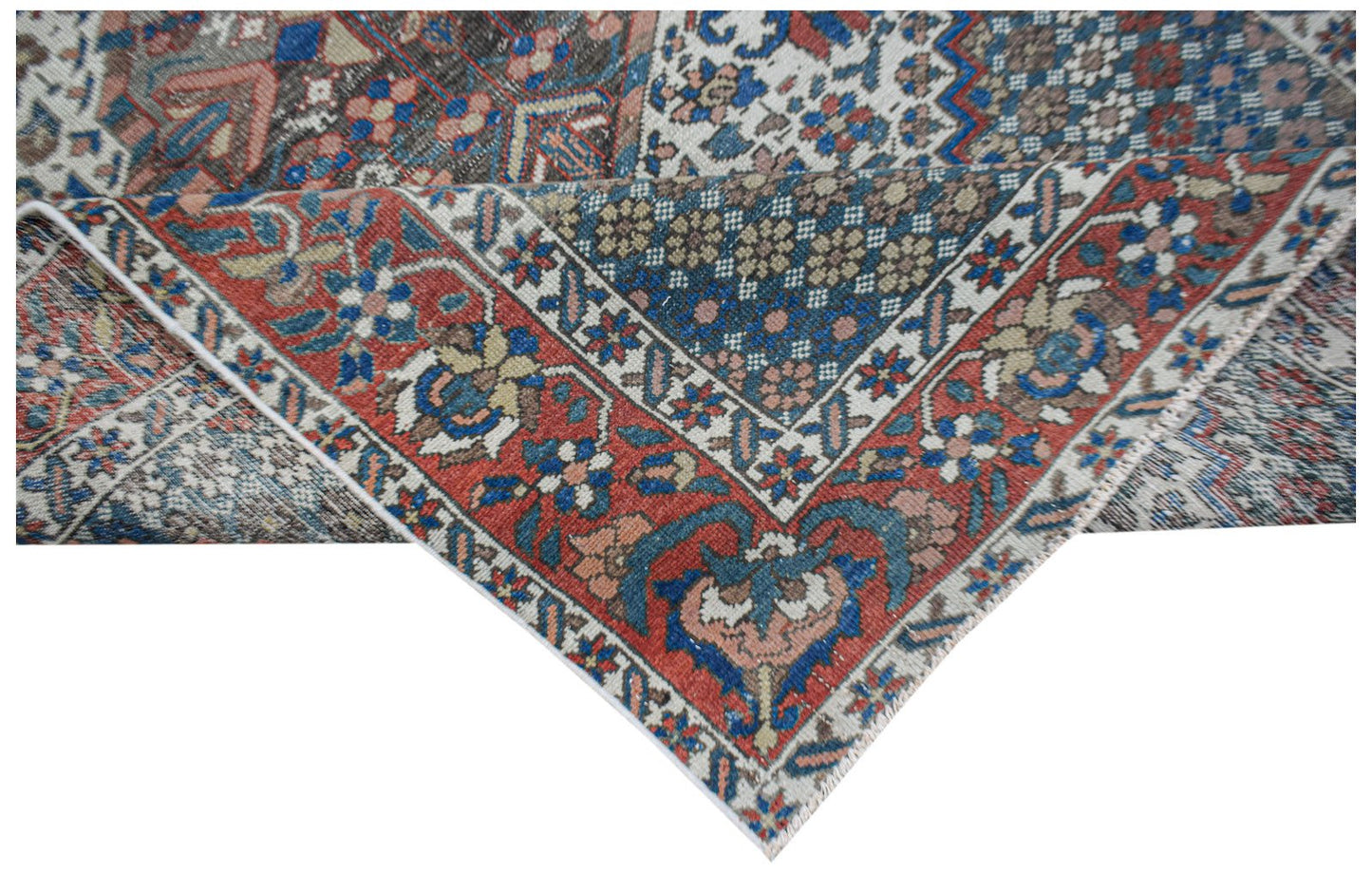 Vintage Persian rug with intricate floral patterns in red, blue, and cream.