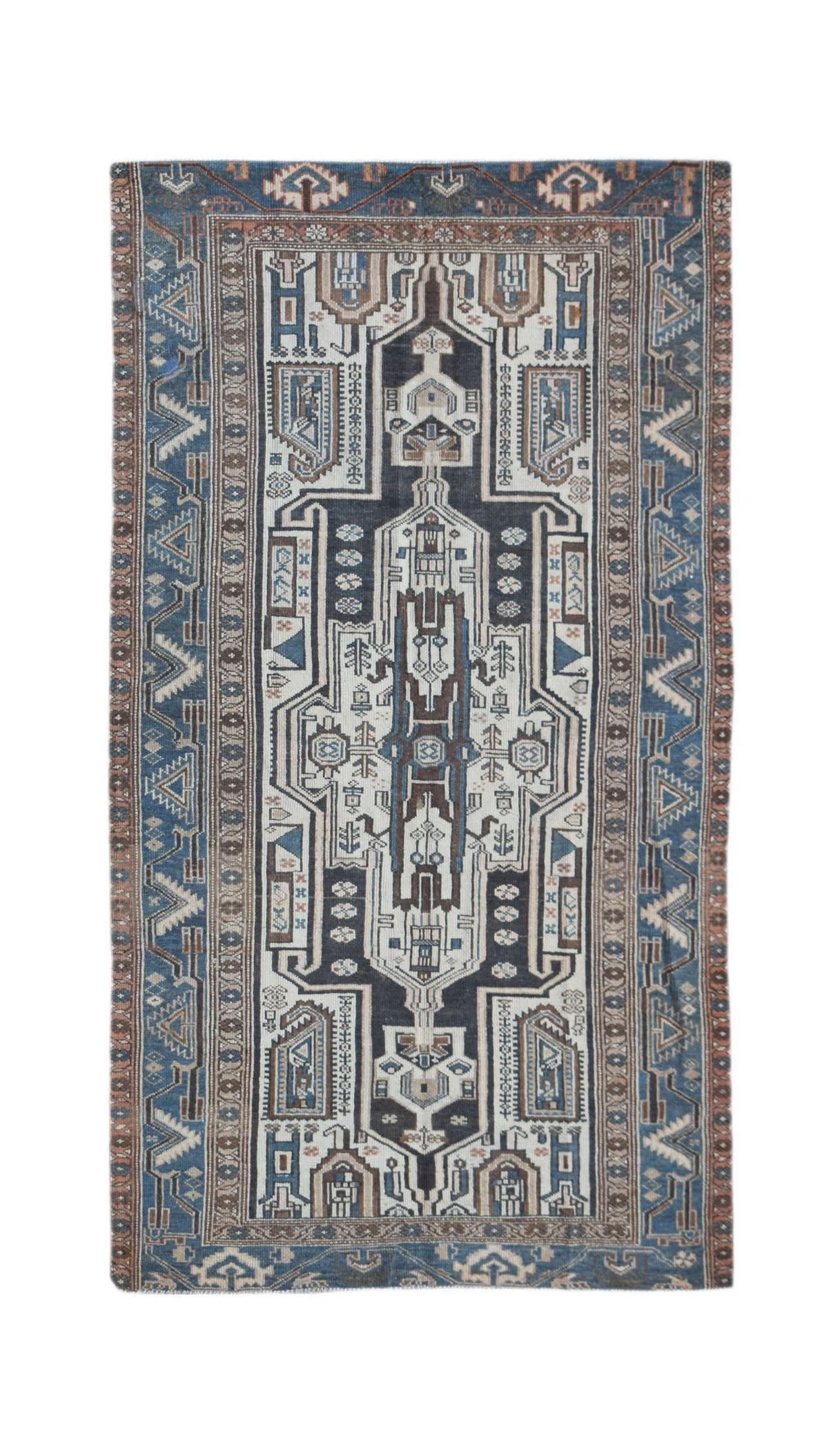 A handwoven vintage Persian rug featuring a geometric central medallion in blue, white, and brown.