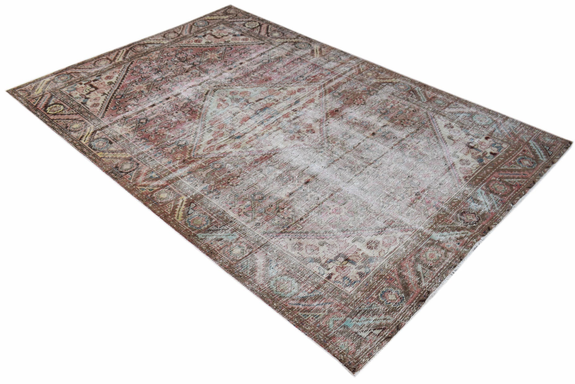 A handwoven vintage Persian rug featuring a faded, distressed pattern in muted earth tones.