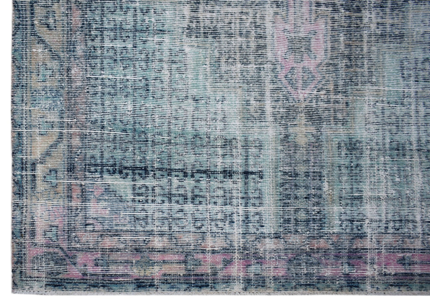 A vintage Persian rug featuring a distressed, faded pattern in shades of blue, pink, and cream.