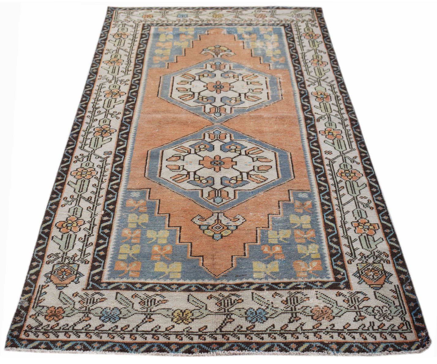 A handwoven vintage Persian rug featuring a geometric medallion pattern in orange and blue tones.