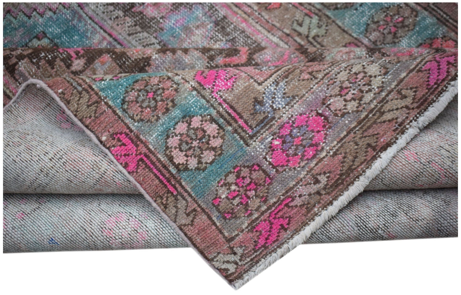A vintage Persian Hamadan rug featuring a distressed floral pattern in pink, teal, and brown.