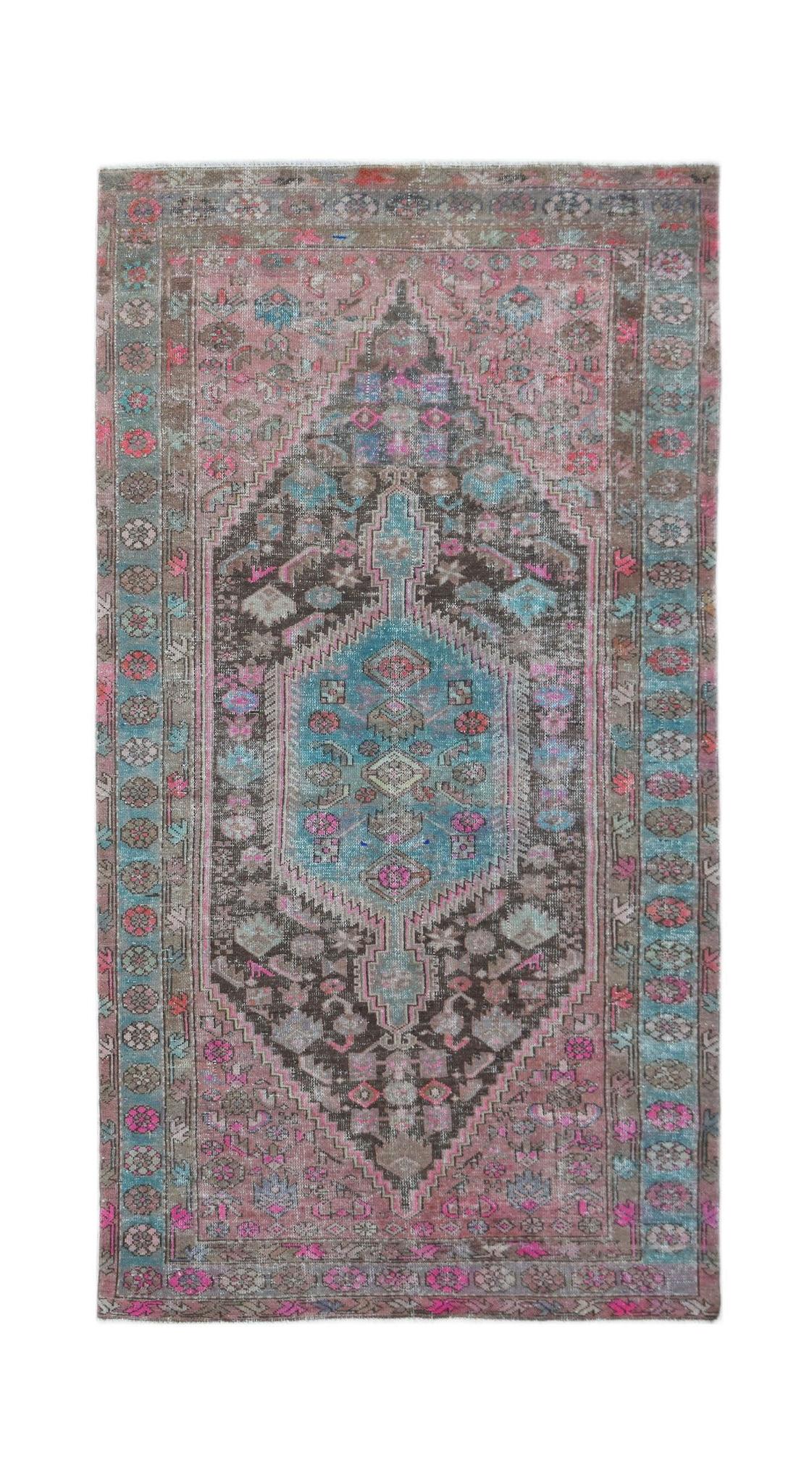 A vintage handwoven Persian Hamadan rug featuring a central medallion in shades of pink and blue.