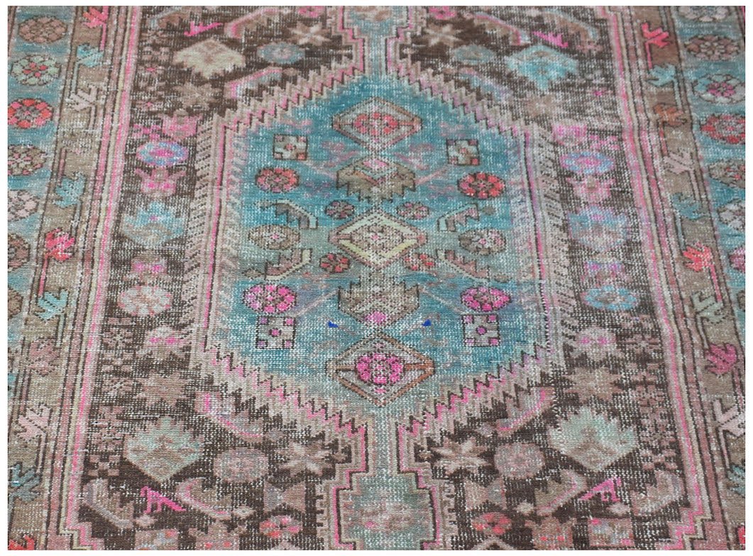 A vintage handwoven Persian Hamadan rug featuring a central medallion in blue, brown, and pink.