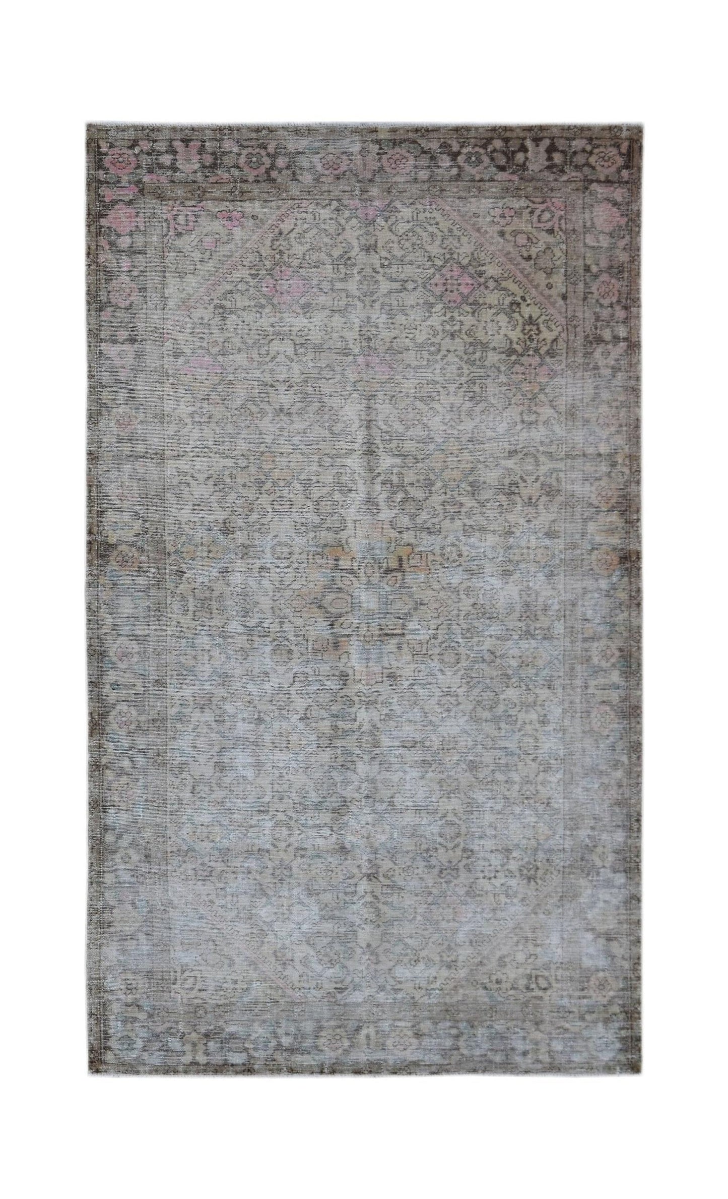 A vintage handwoven Persian rug featuring a faded floral pattern in muted grey and pink tones.