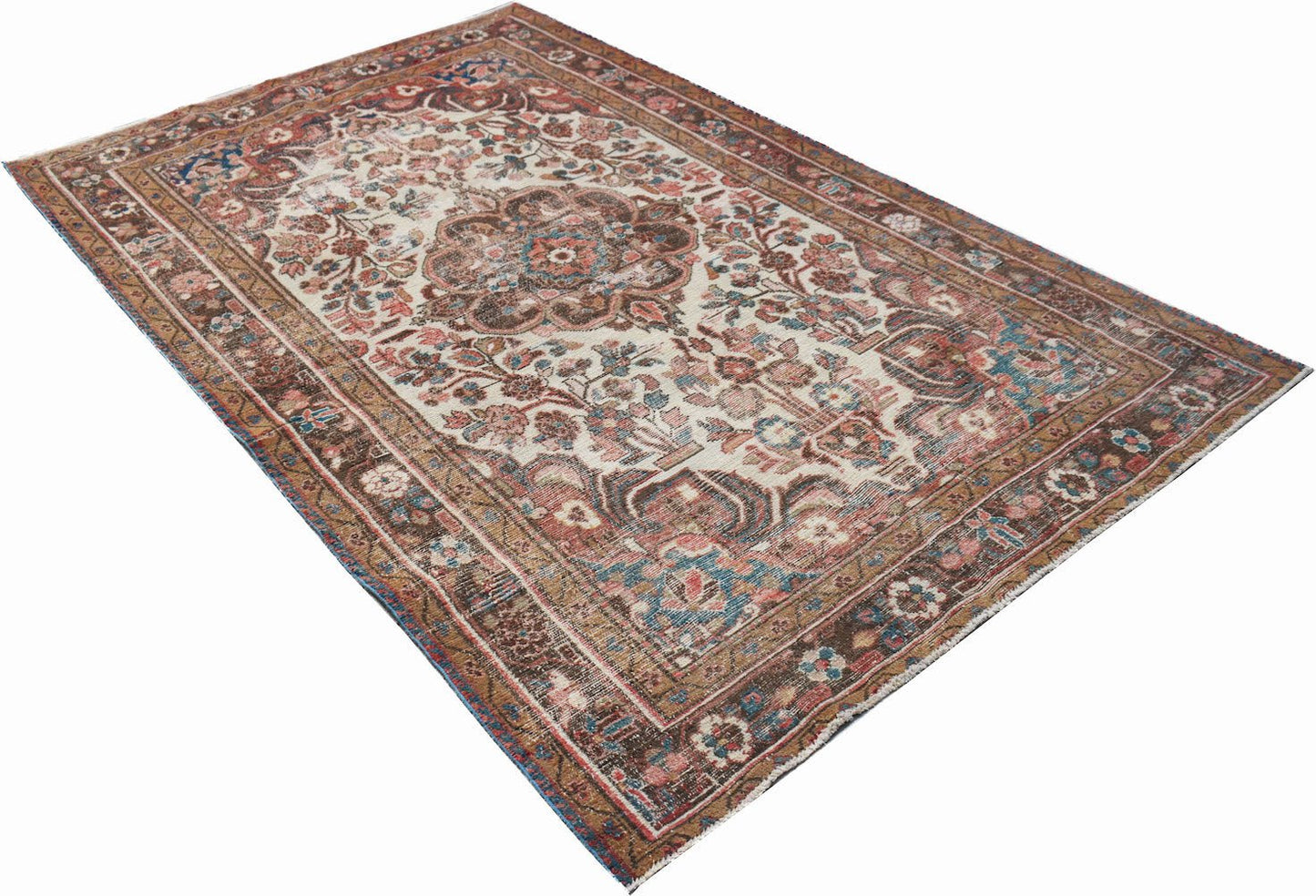 A vintage handwoven Persian rug featuring a central floral medallion on a cream field.