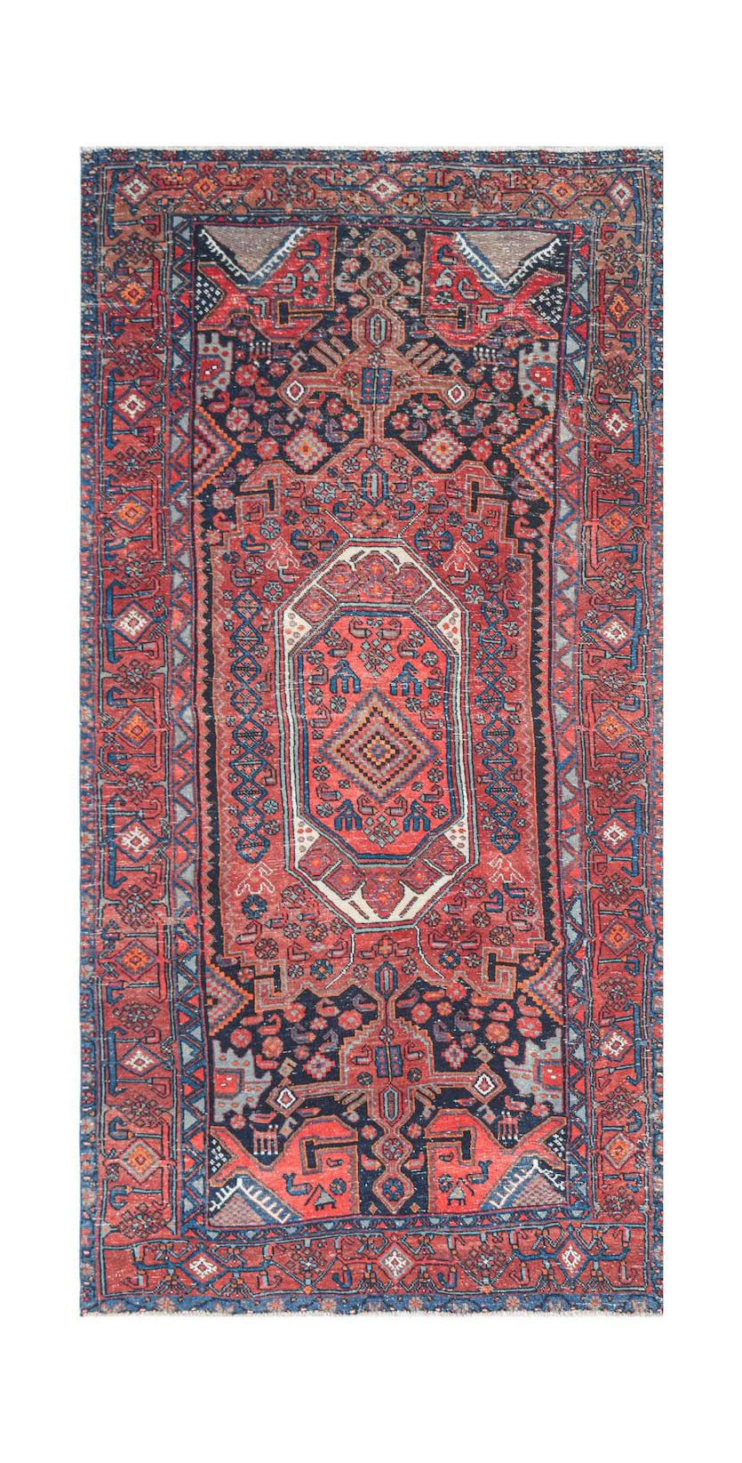 Handwoven vintage Persian rug featuring a central medallion on a red and navy blue patterned field.