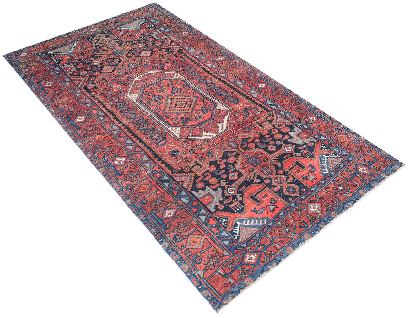 Vintage Persian rug with red, blue, and white geometric patterns.