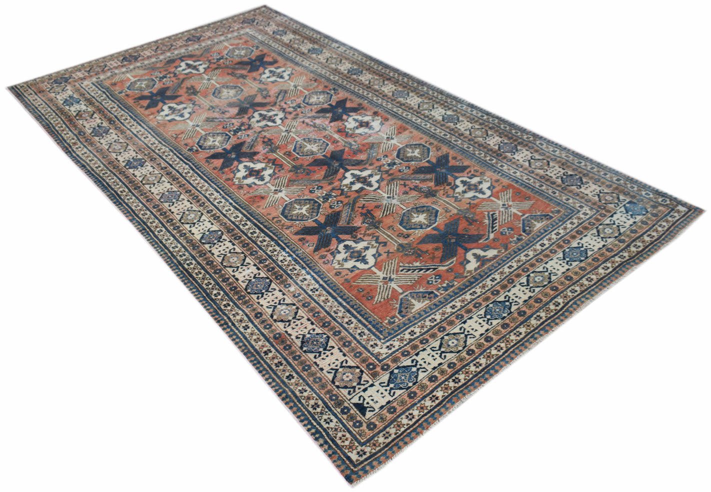 A vintage handwoven Persian rug featuring a geometric pattern in shades of red, blue, and cream.