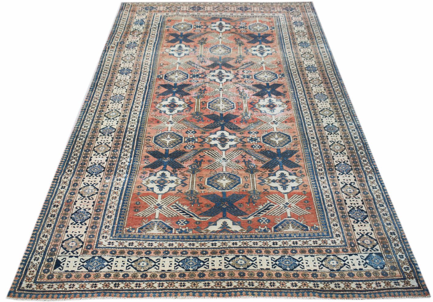 Handwoven vintage Persian rug featuring a geometric pattern in shades of red, blue, and cream.