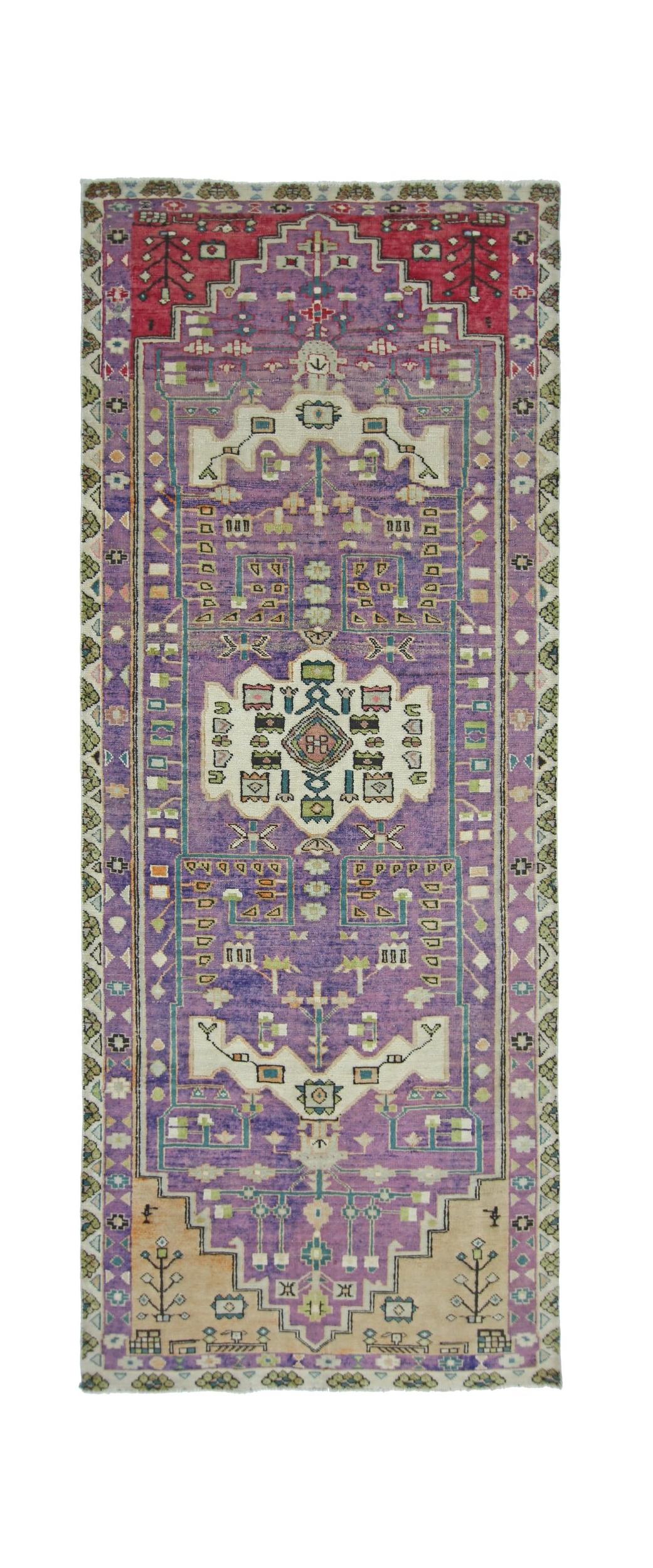 A handmade vintage Persian runner rug featuring a purple field with geometric patterns.