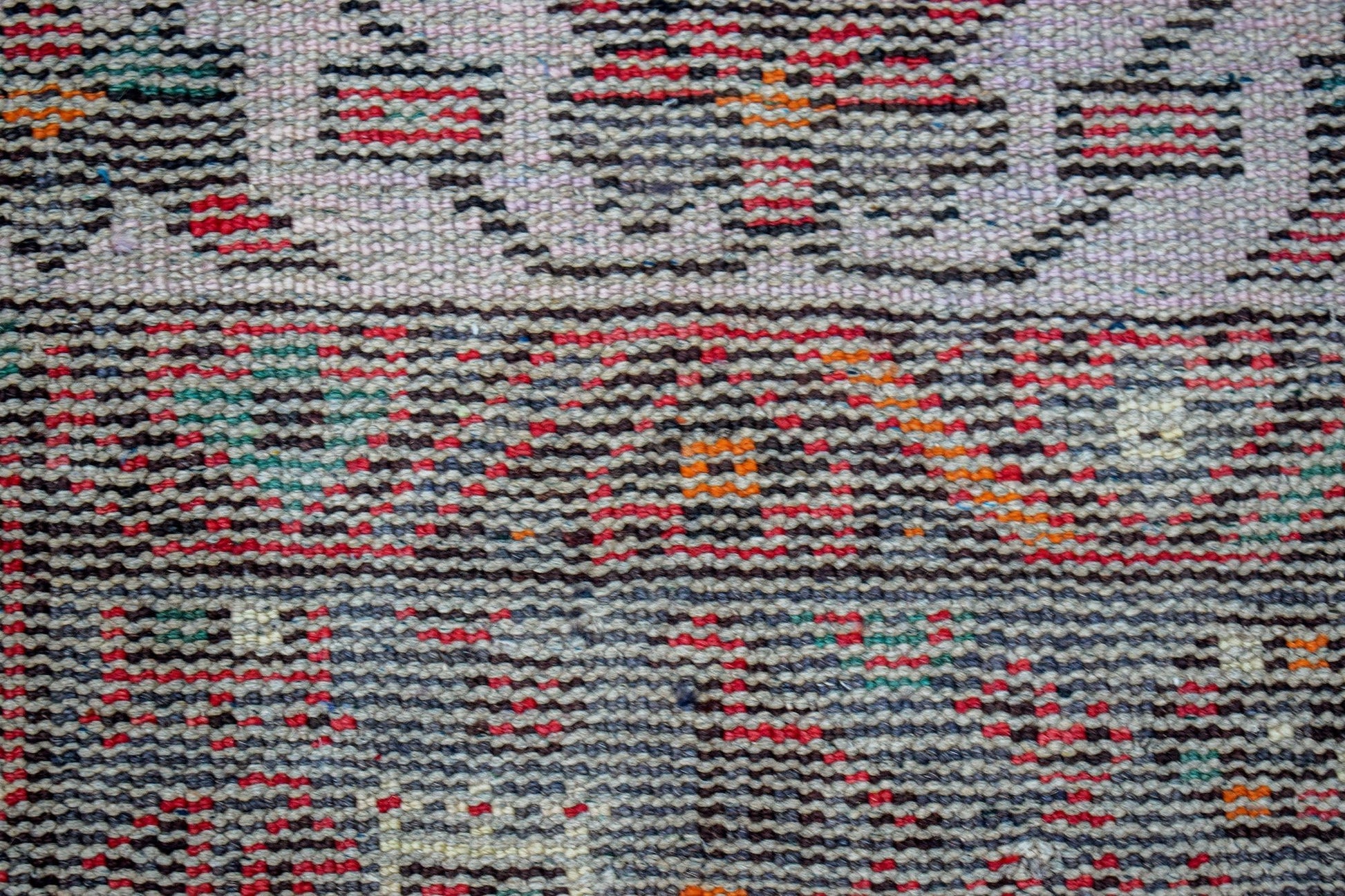 A close-up view of a handwoven vintage Persian rug featuring a textured pattern of colorful threads.