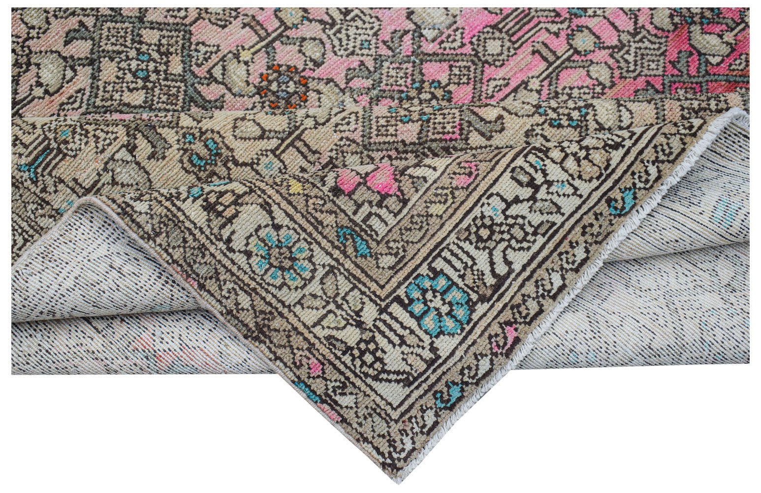 A handwoven vintage Persian rug featuring a distressed floral pattern in pink, blue, and beige.
