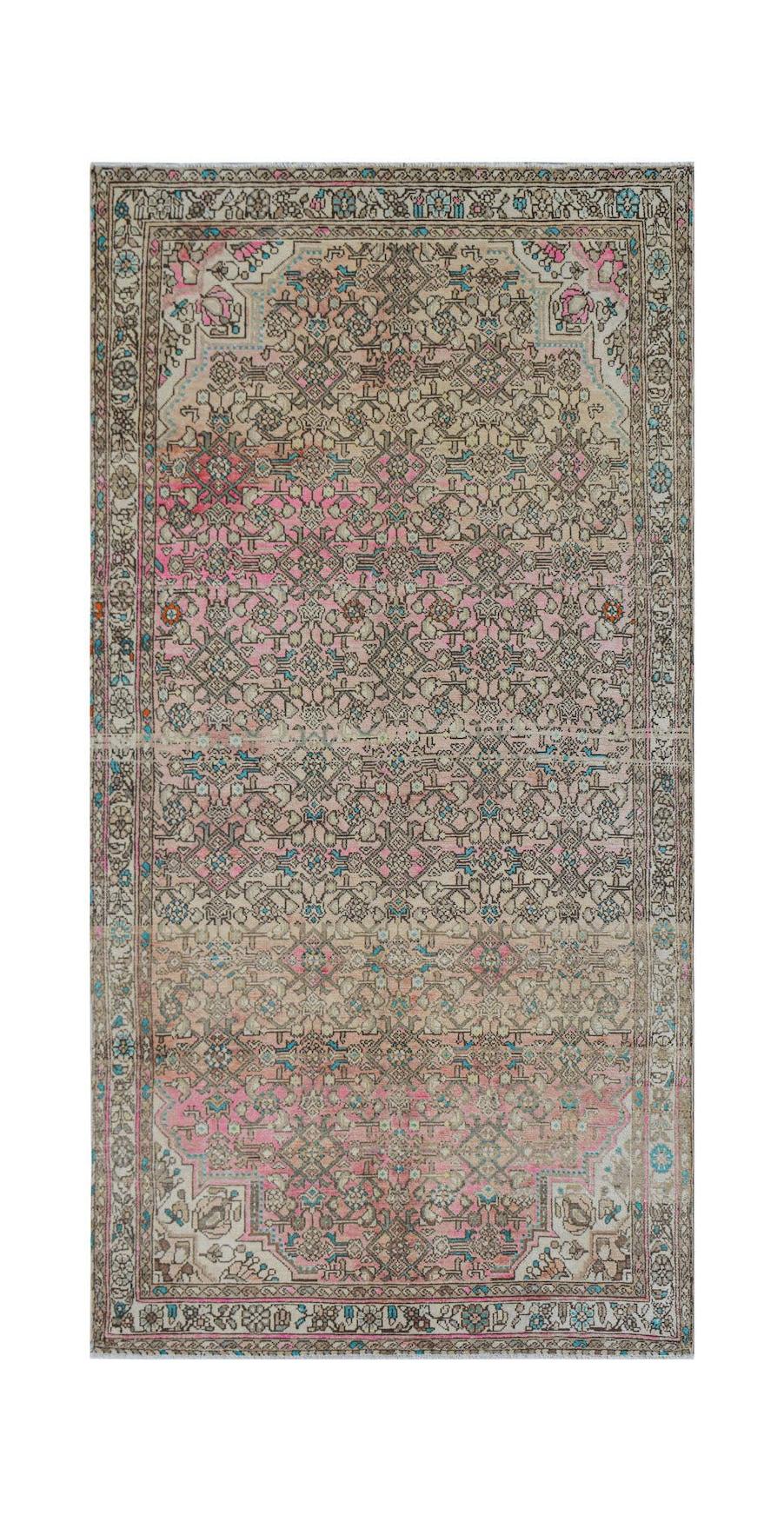Vintage Persian rug with pink and beige floral patterns.