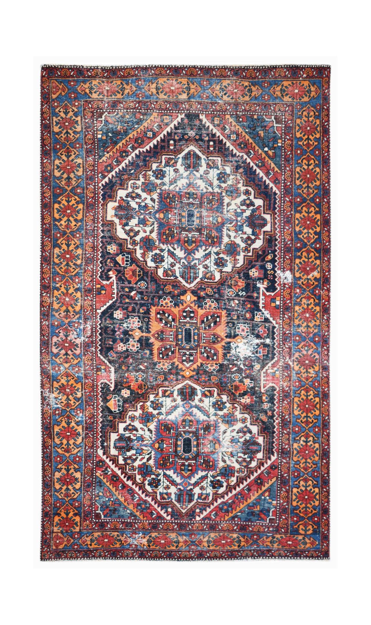A rectangular vintage Persian rug featuring a traditional geometric pattern in blue and red tones.
