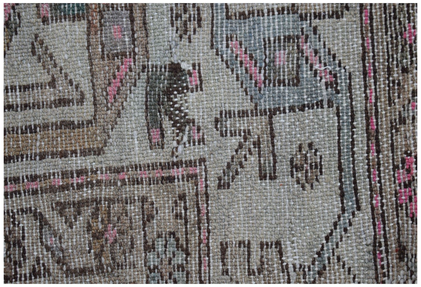A close-up of a handwoven vintage Persian rug featuring intricate geometric patterns in wool.