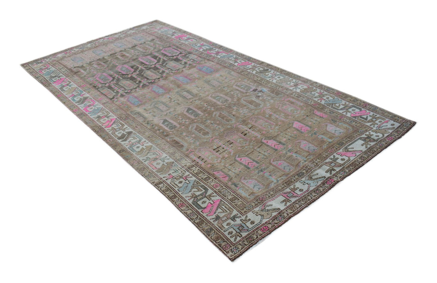 A handwoven vintage Persian rug featuring a distressed brown field with pink and blue accents.