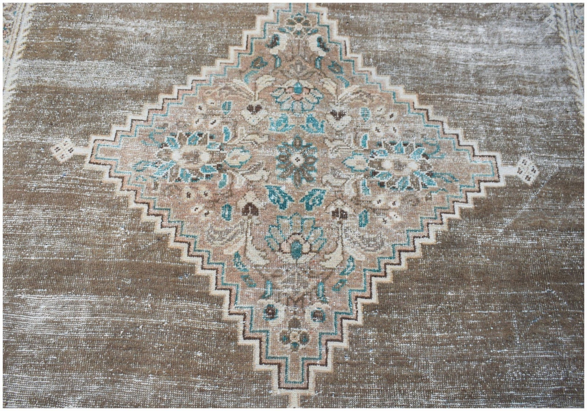 A vintage Persian Mahal rug featuring a central diamond medallion with floral motifs in blue and tan.