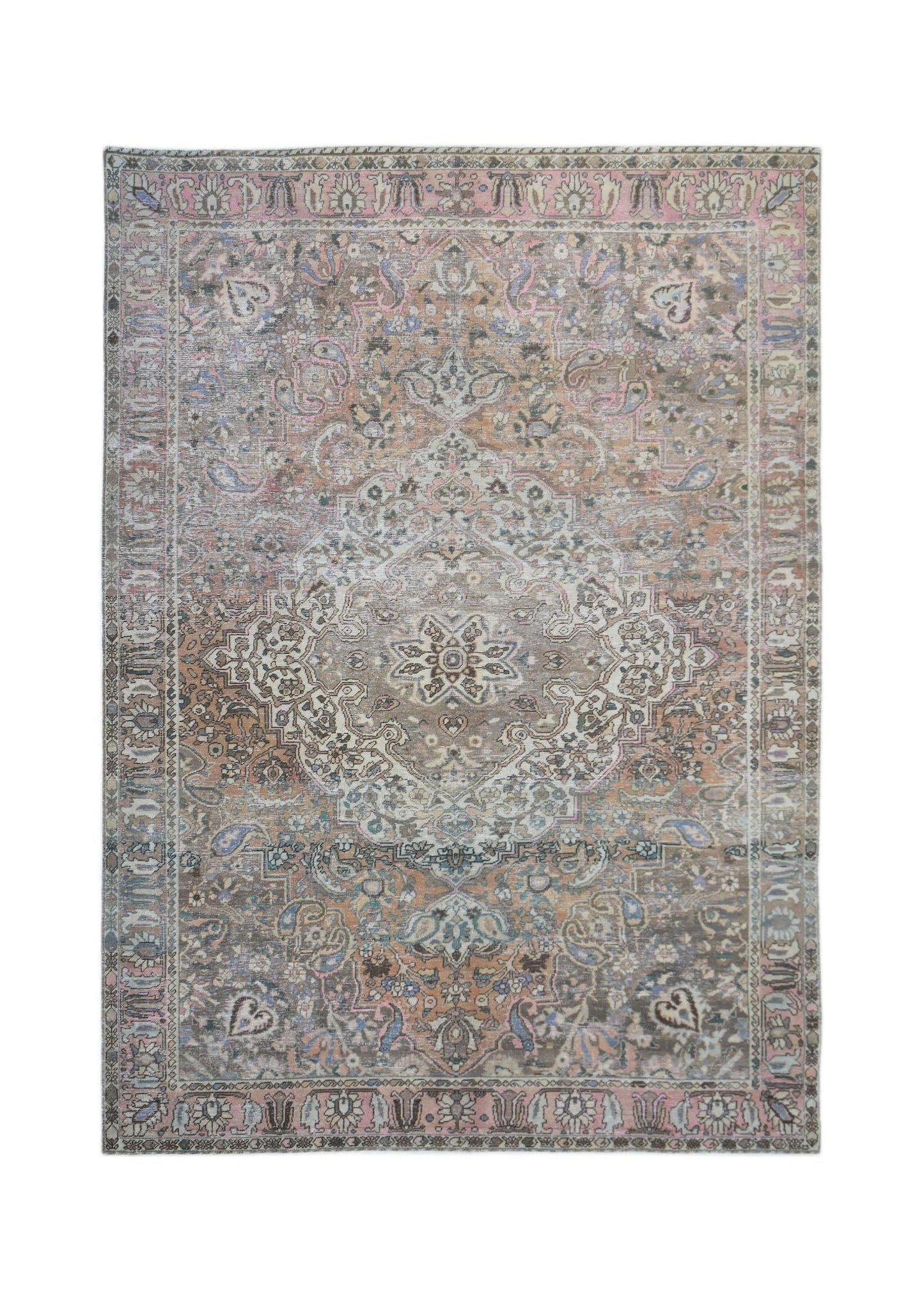 A vintage handwoven Persian rug featuring a faded floral medallion pattern in muted earth tones.