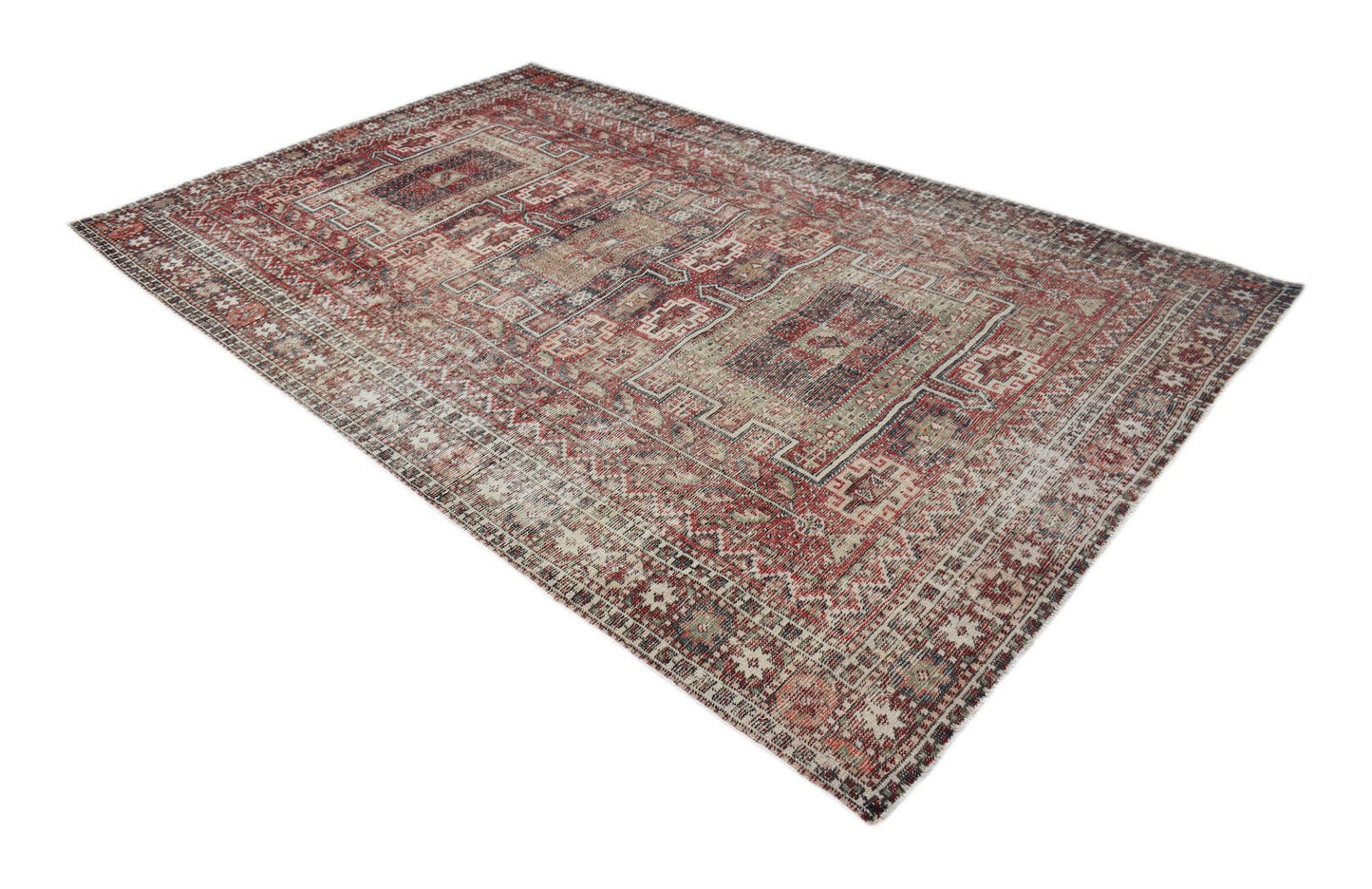 A rectangular vintage Persian rug featuring intricate geometric patterns in faded red and blue tones.