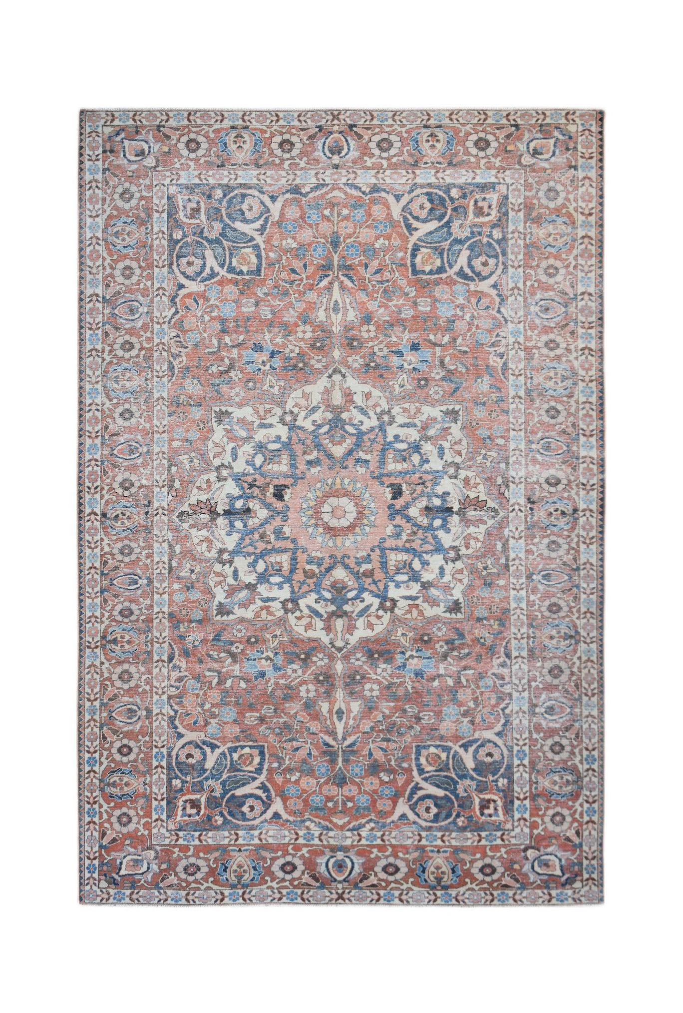 A vintage Persian rug featuring a central floral medallion in shades of blue, cream, and rust red.