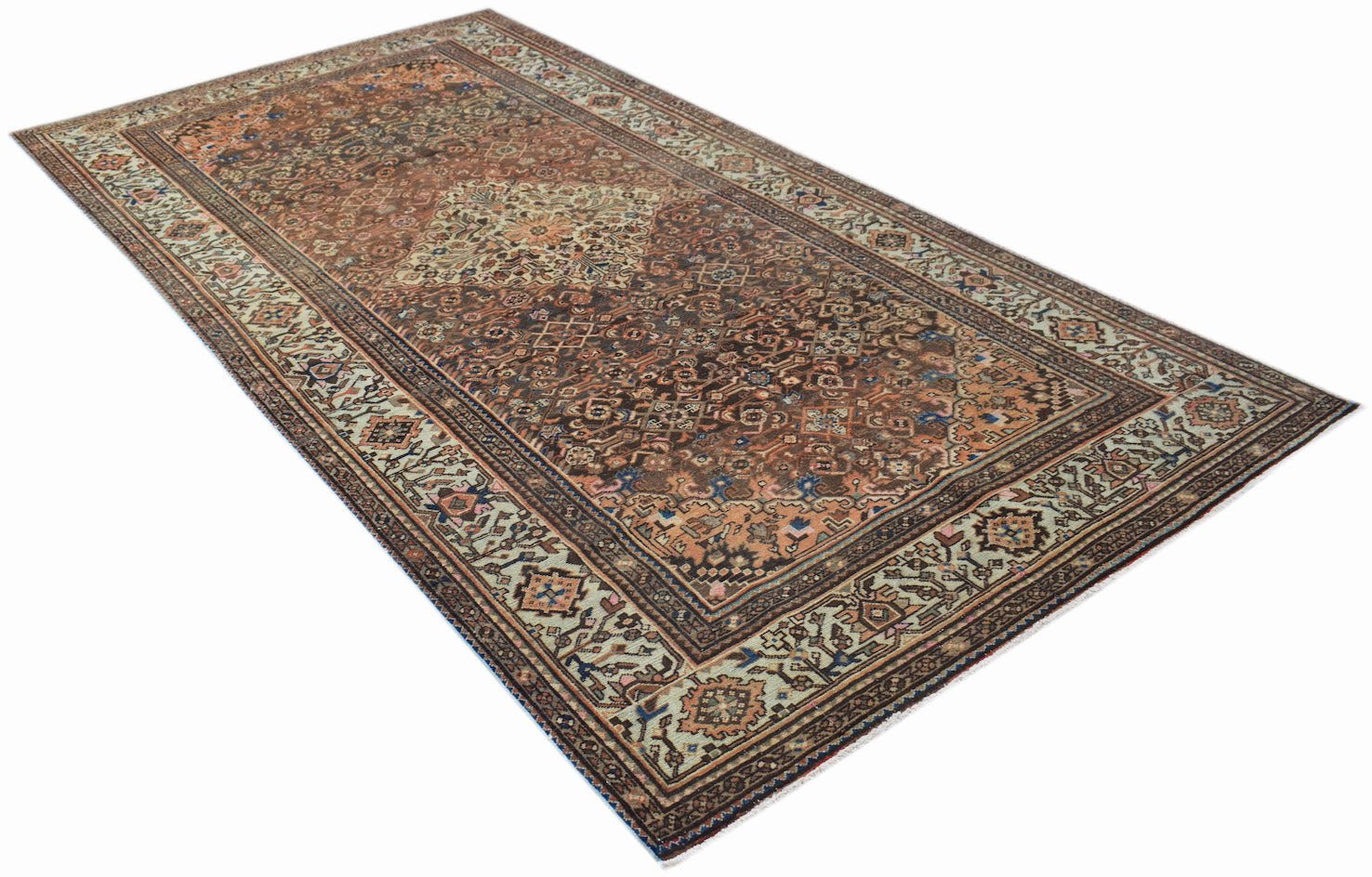 A vintage handwoven Persian rug featuring a detailed floral pattern in brown and muted tones.
