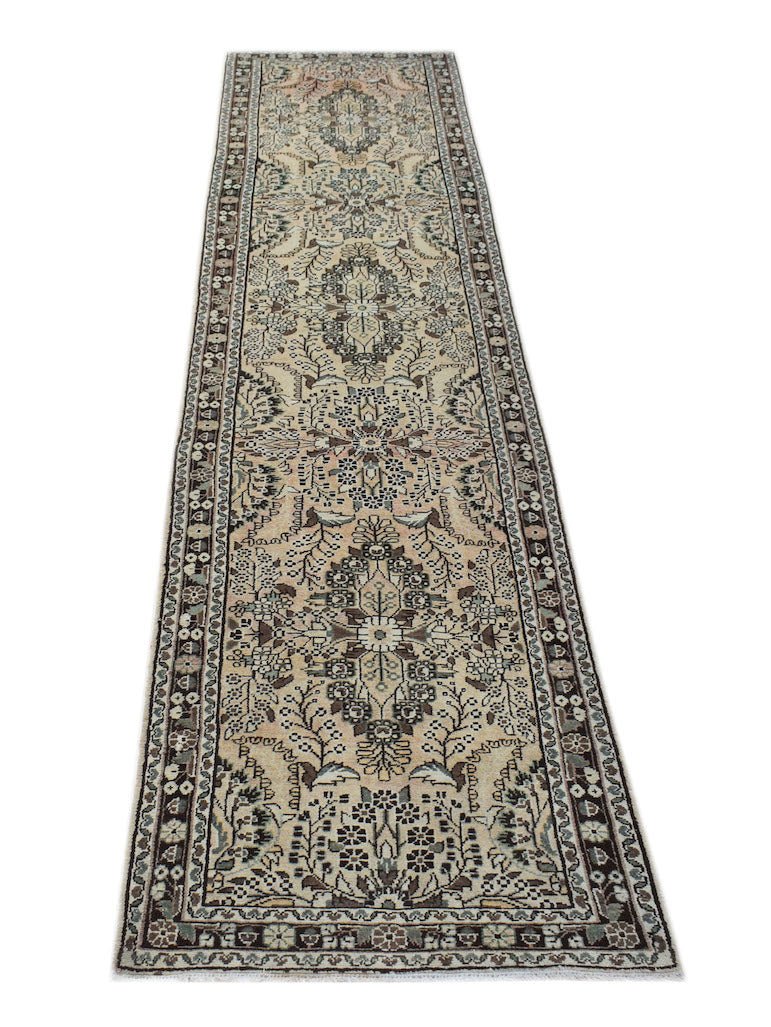 A vintage Persian Sarouk runner featuring a floral pattern in muted tones on a cream background.