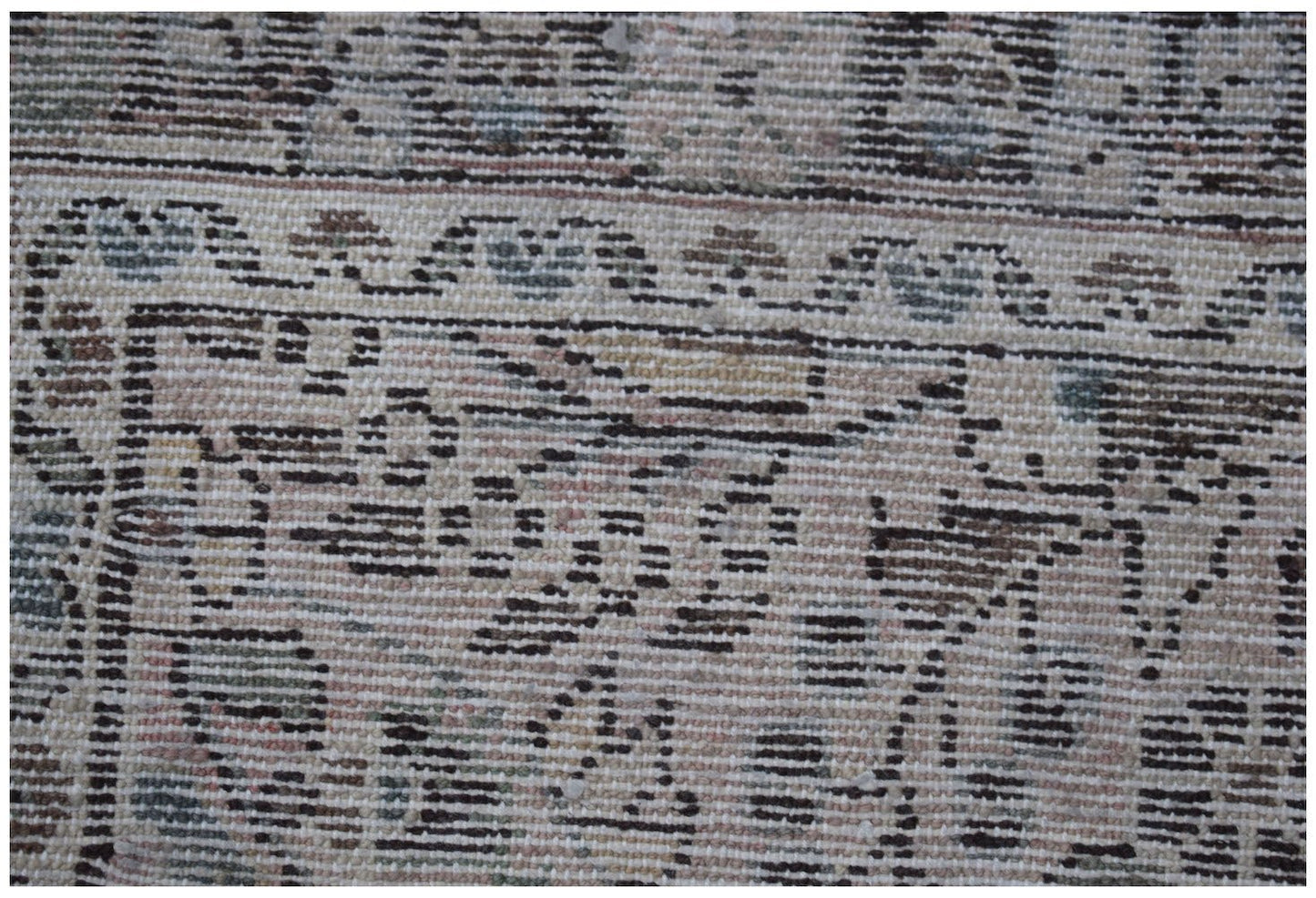 A close-up of a vintage Persian Sarouk runner featuring intricate floral patterns in muted tones.