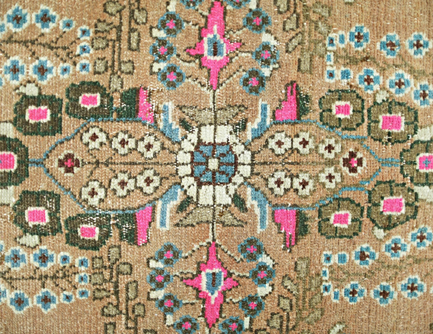 A vintage Persian Sarouk rug featuring a floral medallion pattern in pink, blue, and tan.