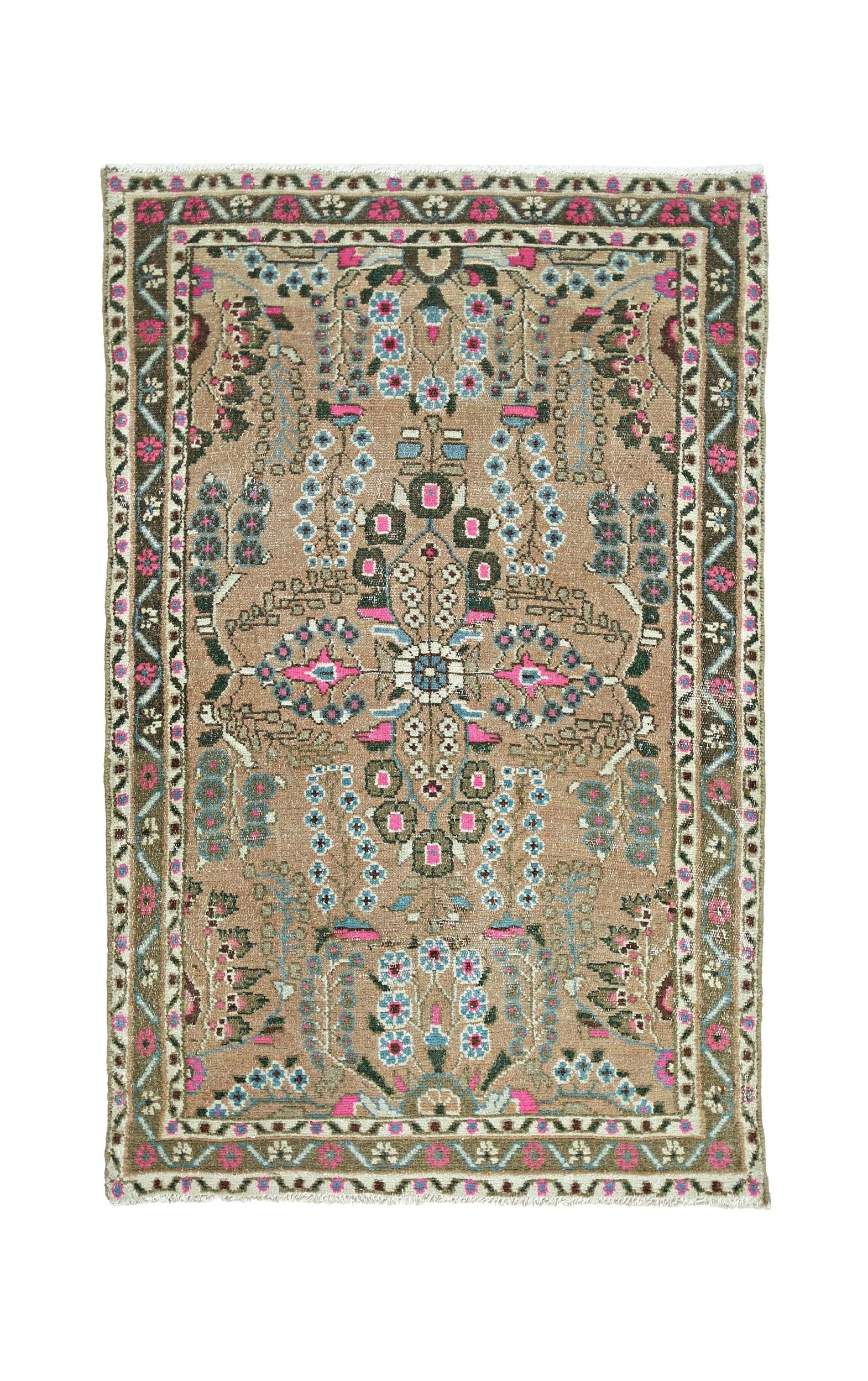 A vintage Persian Sarouk rug featuring a floral medallion pattern in pink, blue, and tan tones.