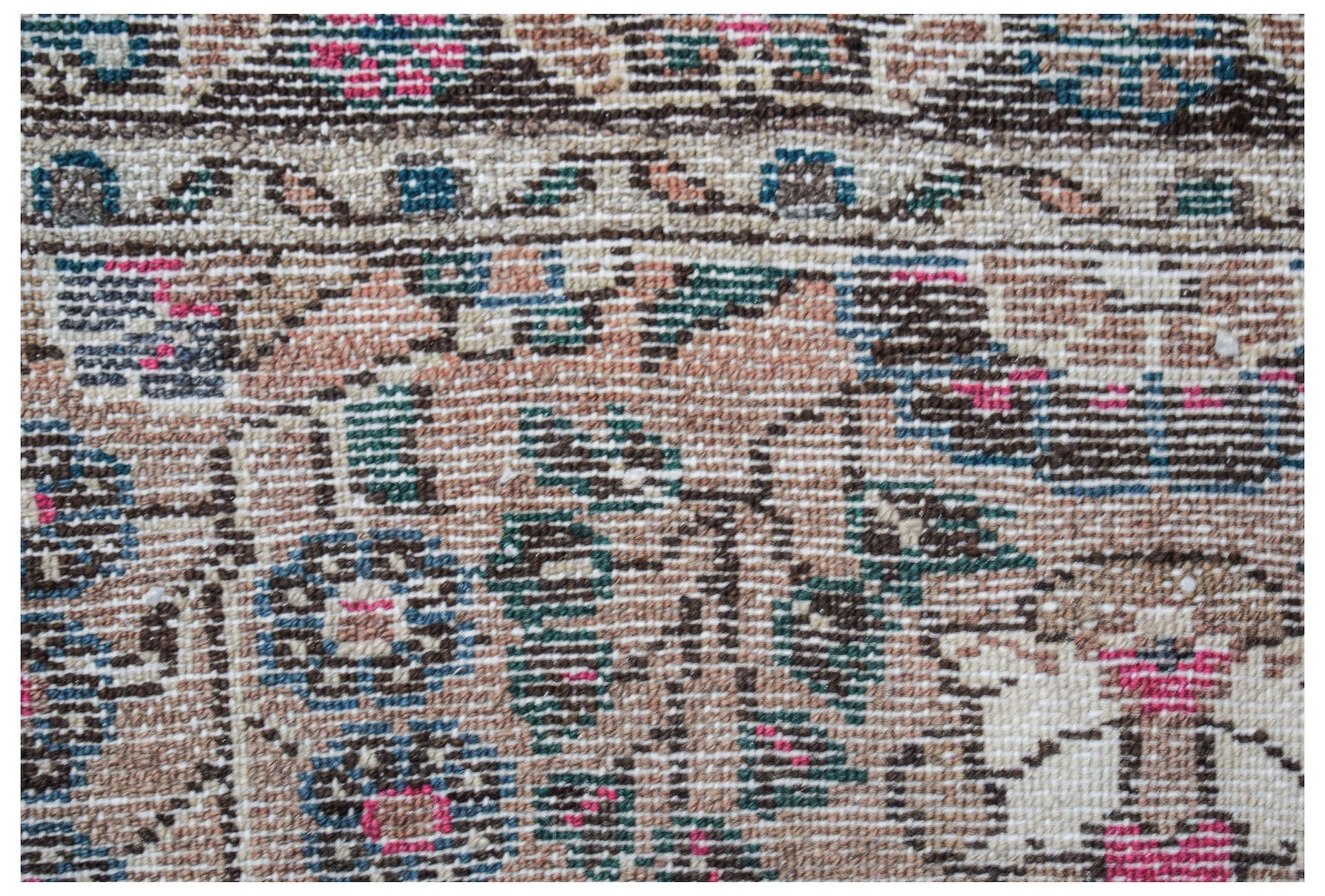 A close-up view of a vintage Persian Sarouk rug featuring intricate floral patterns in wool.