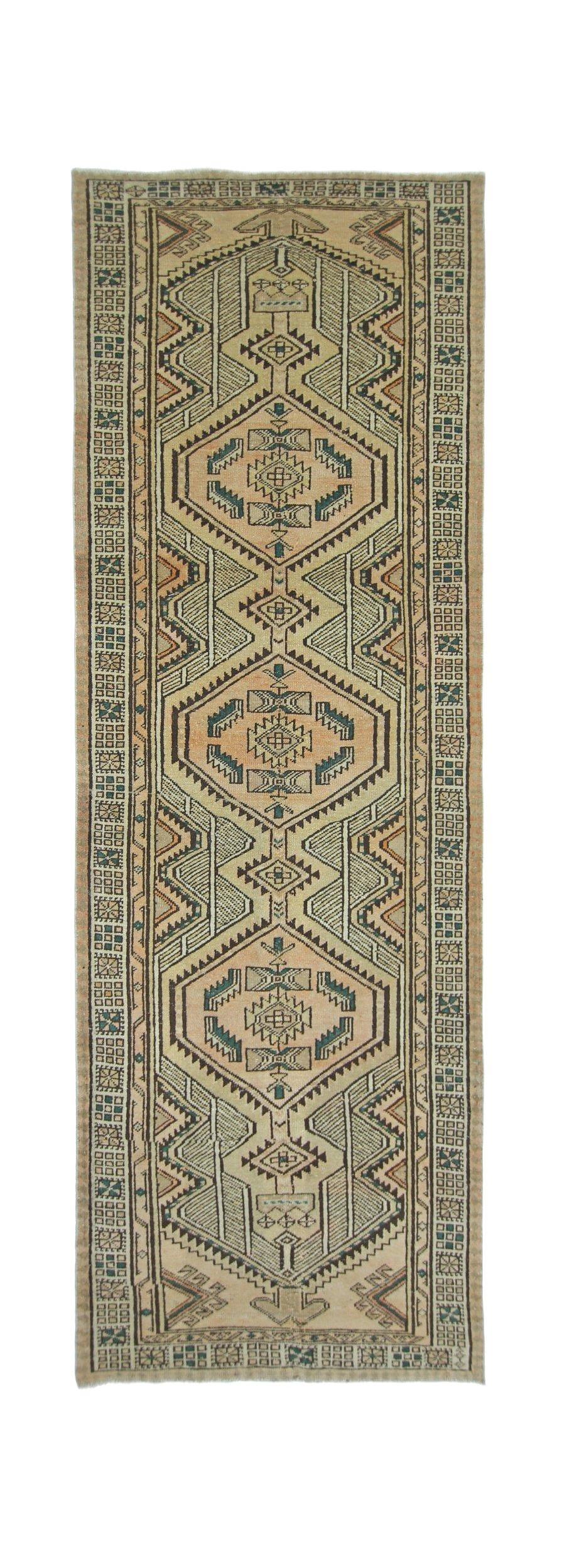 A vintage Persian Serab runner featuring a geometric diamond pattern in muted earth tones.