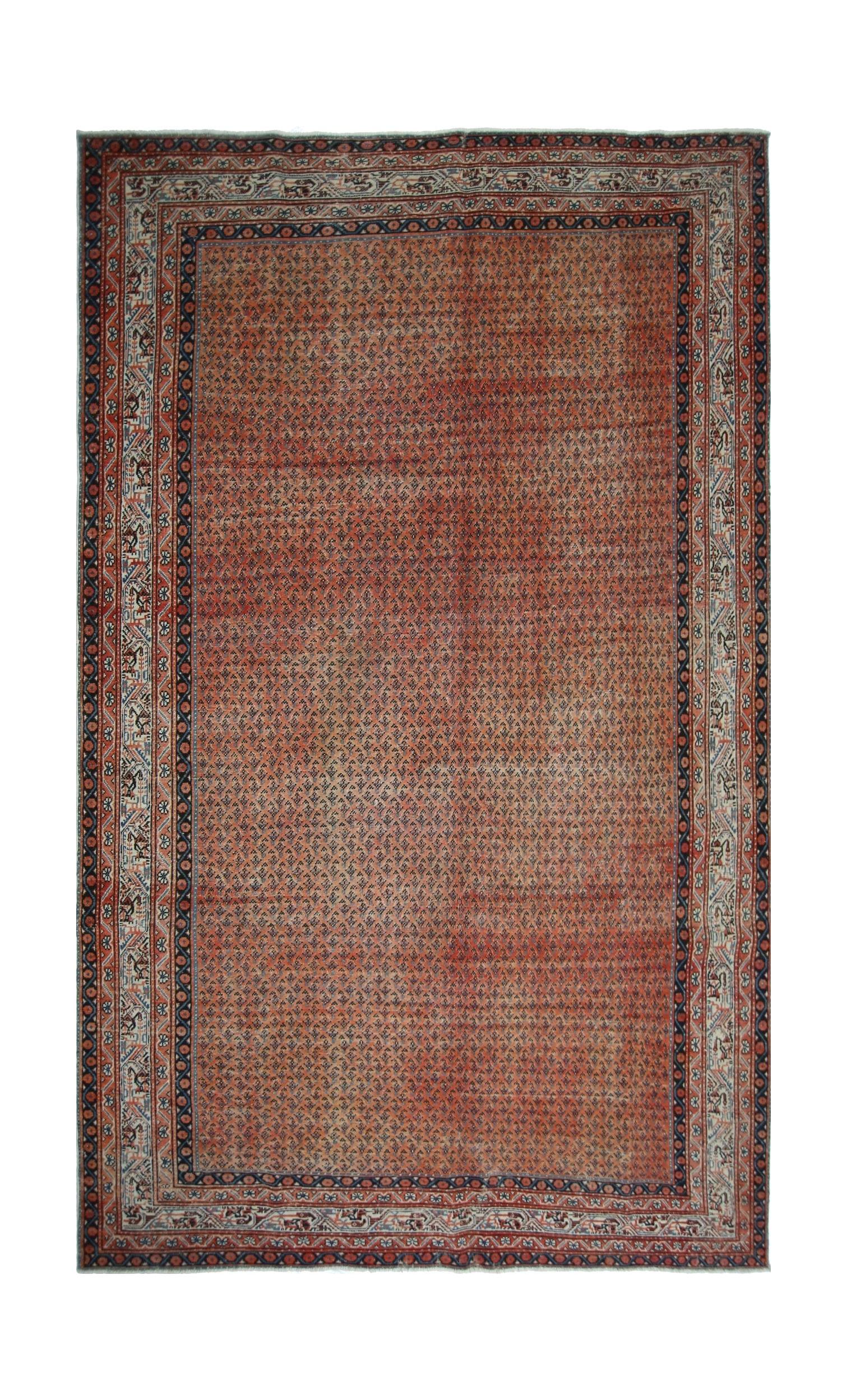 A vintage Persian Saraband rug featuring a repeating boteh pattern on a rust-colored field.