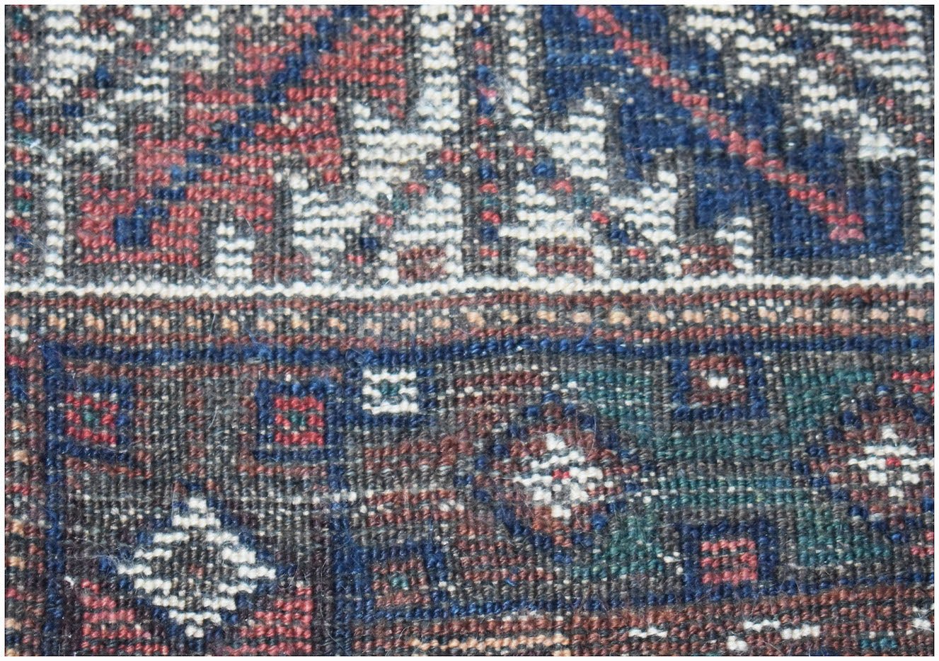 A close-up of a vintage Persian Shiraz rug featuring intricate geometric patterns in wool.